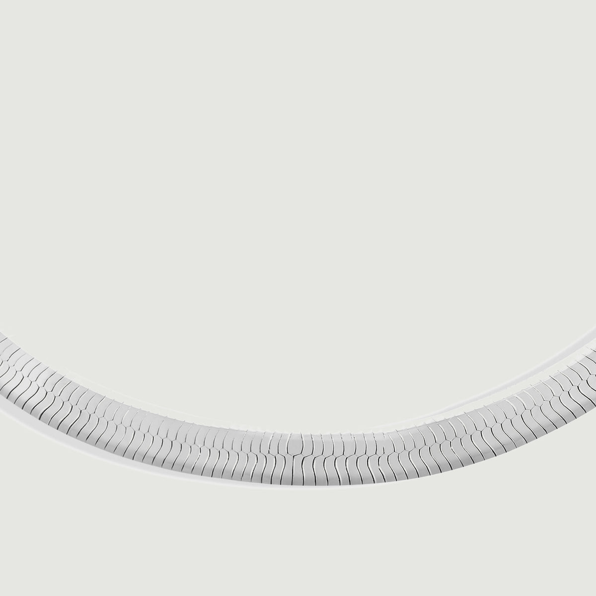 A close view shows the interlocking silver links along the curved lower section of the bracelet.