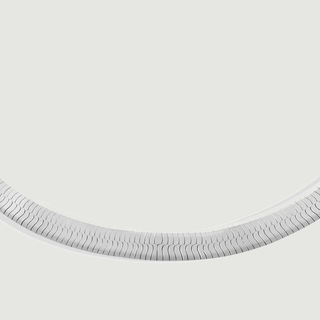 A close view shows the interlocking silver links along the curved lower section of the bracelet.