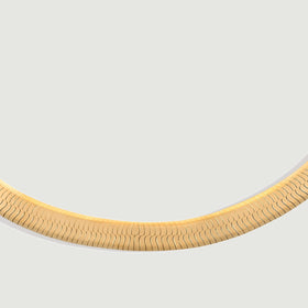 Polished yellow gold links follow a shallow curve against a clean gray background.
