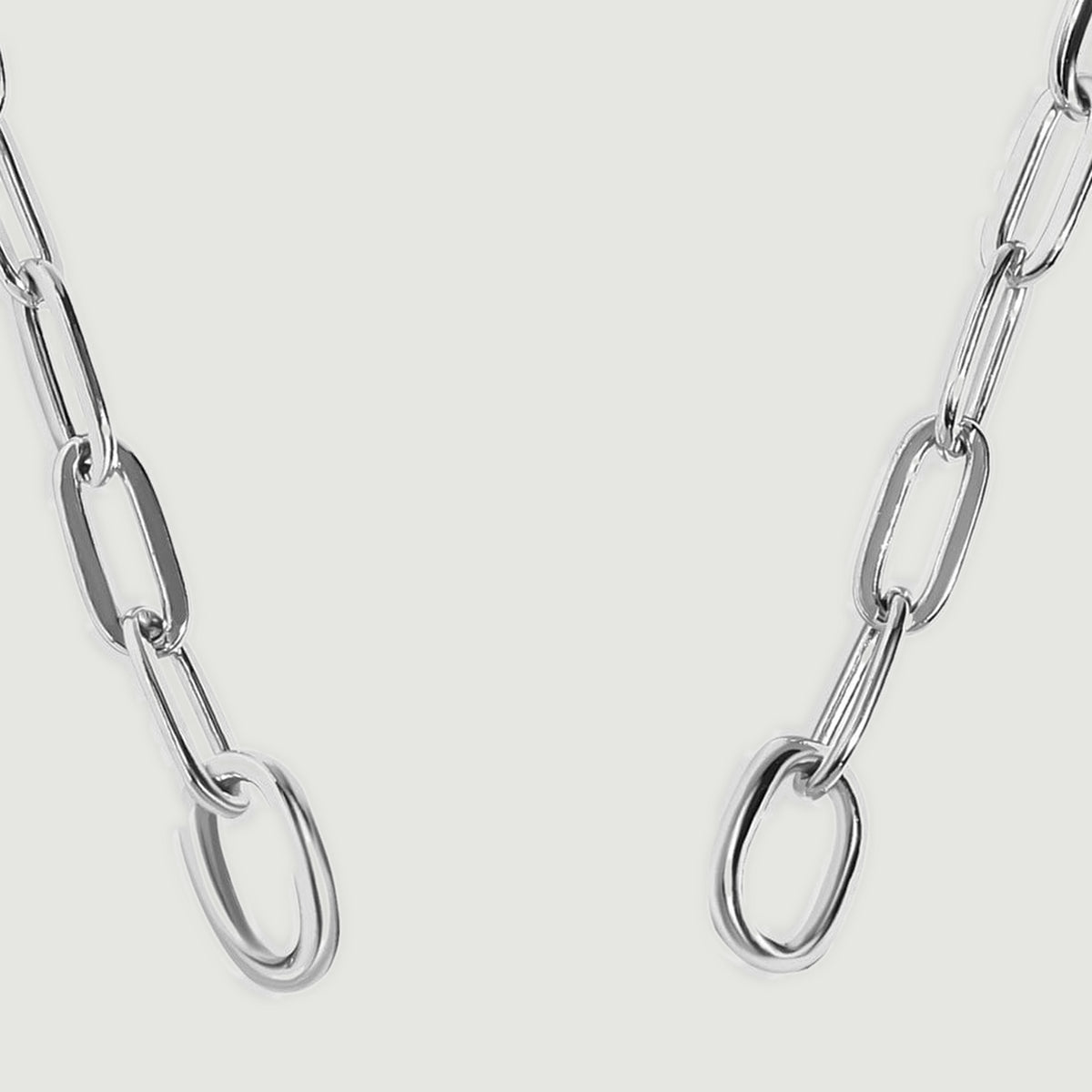 Two circular silver end rings connect to elongated chain links in this close view.
