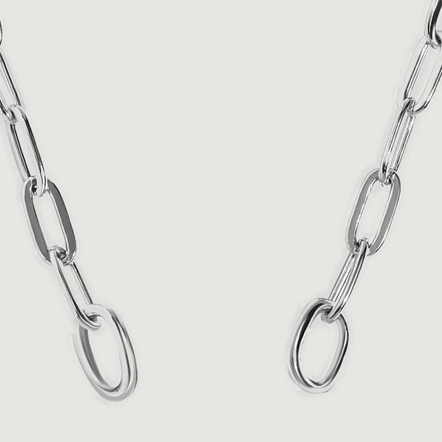 Two circular silver end rings connect to elongated chain links in this close view.
