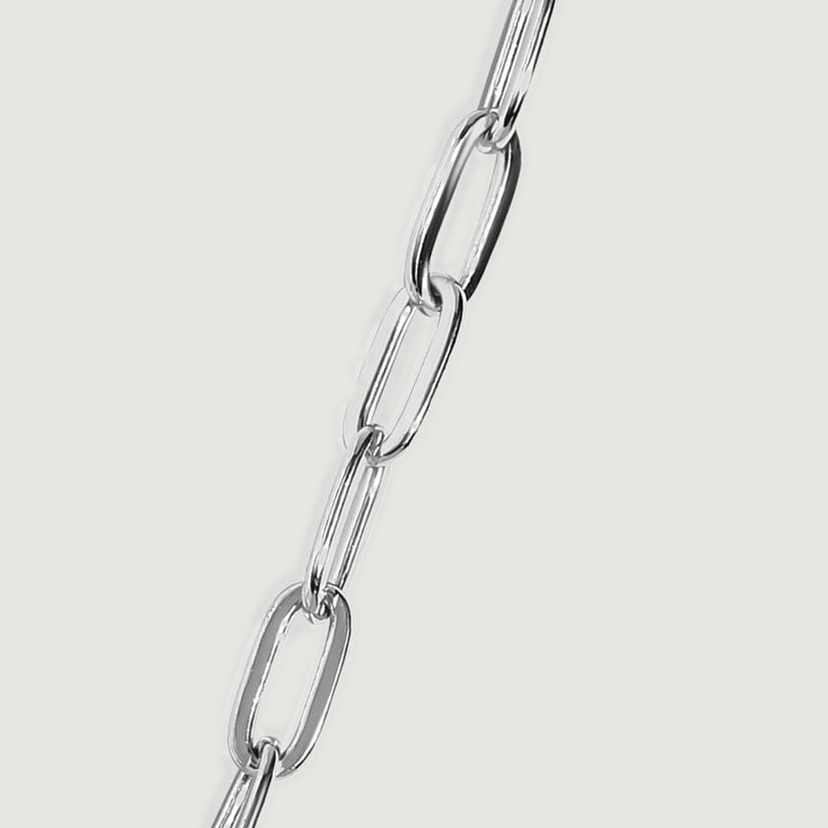 A silver chain segment shows broad oval links alternating with narrow links viewed at an angle.
