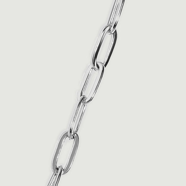 A silver chain segment shows broad oval links alternating with narrow links viewed at an angle.
