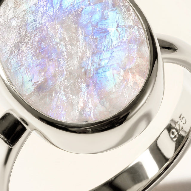 A close view shows the moonstone surface, curved silver setting, and 925 stamp inside the band.