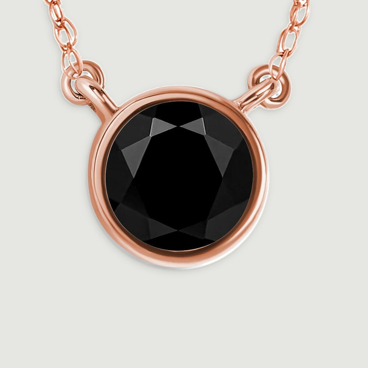 The black onyx facets and warm rose gold rim are visible beside the small connecting links.