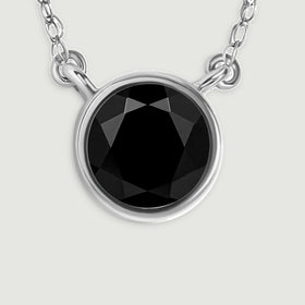 A detailed view reveals the glossy black stone, bright white gold bezel, and paired chain connections.