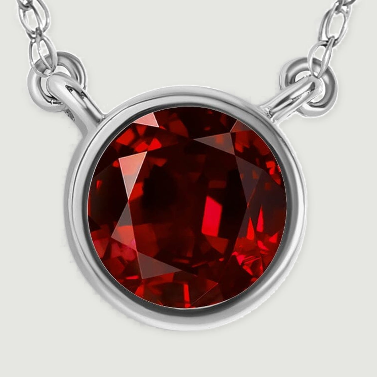 A detailed view reveals the white gold setting around the garnet and the links attached at each side.