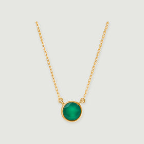 A round green onyx pendant in yellow gold hangs between two fine chain sections on a light gray background.