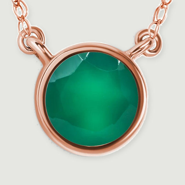 The circular green gemstone and curved rose gold rim fill a close-up with short chain sections above.
