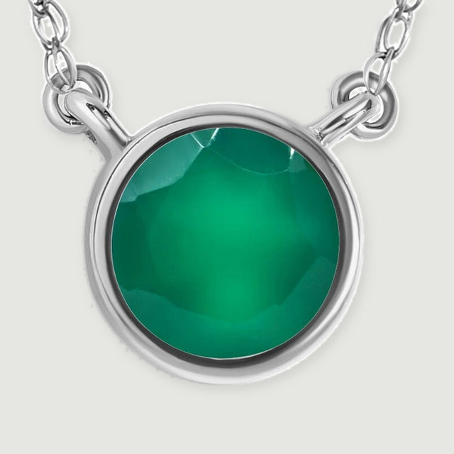 A polished white gold bezel surrounds a faceted green onyx stone in this detailed pendant view.