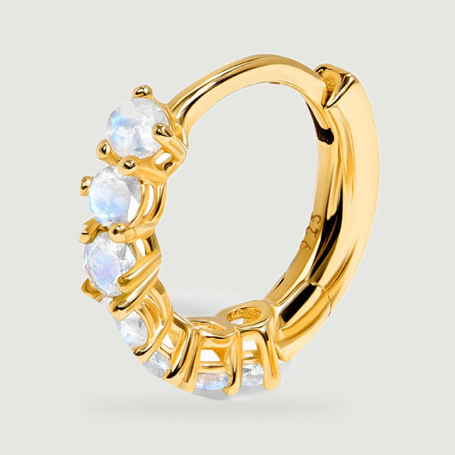 The yellow gold hoop is shown closely with pale faceted moonstones along its curved front.
