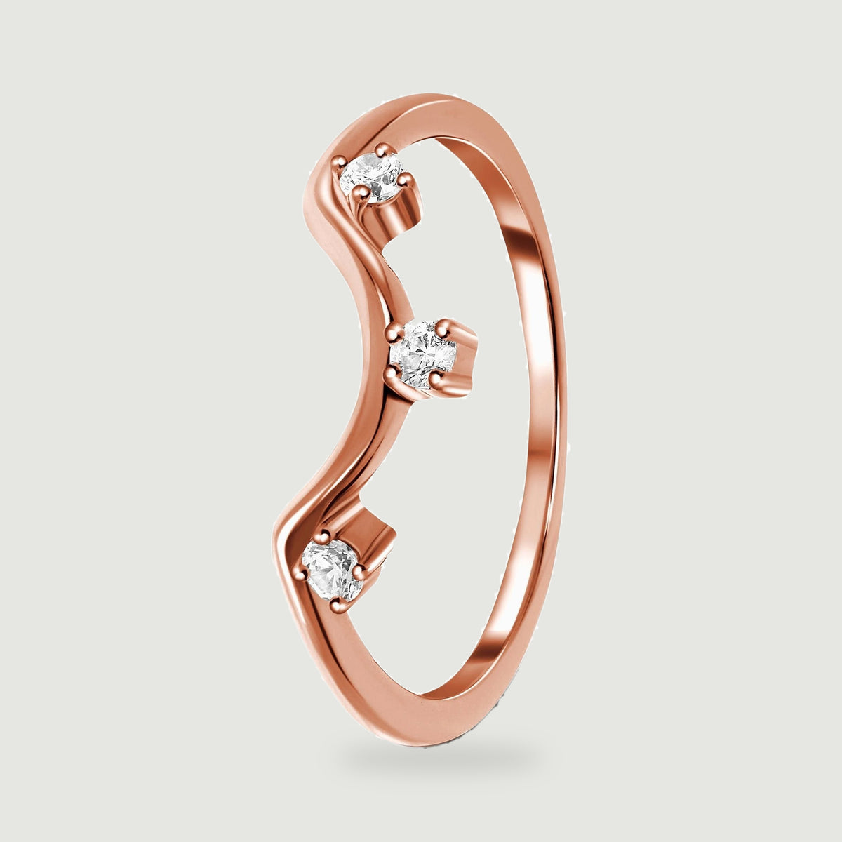 A rose gold ring stands at an angle with its wavy front and three clear stones in view.