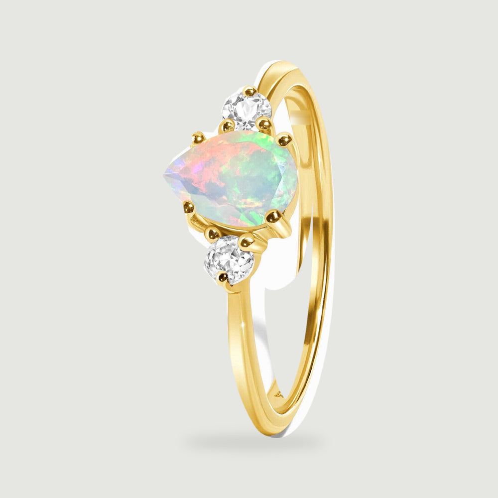 An angled yellow gold ring shows the raised opal setting and its smooth curved band.