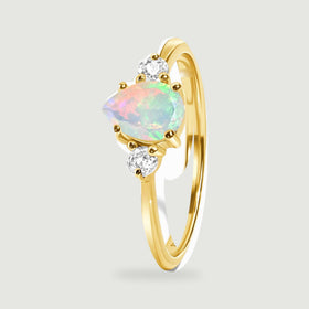 An angled yellow gold ring shows the raised opal setting and its smooth curved band.