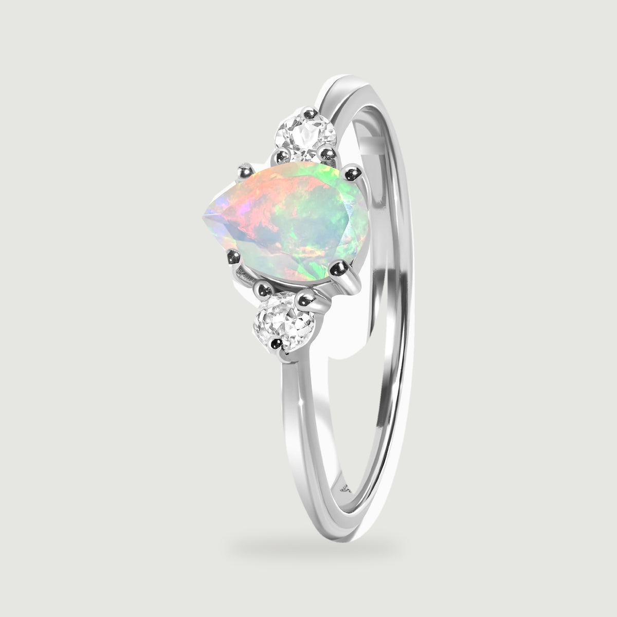 The silver ring stands at an angle with the opal and small round stones above the band.