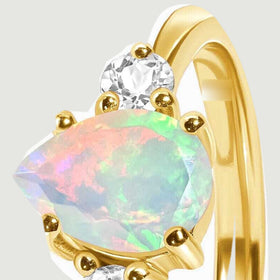 A tilted close-up reveals the opal facets, gold prongs, and the raised side of the setting.