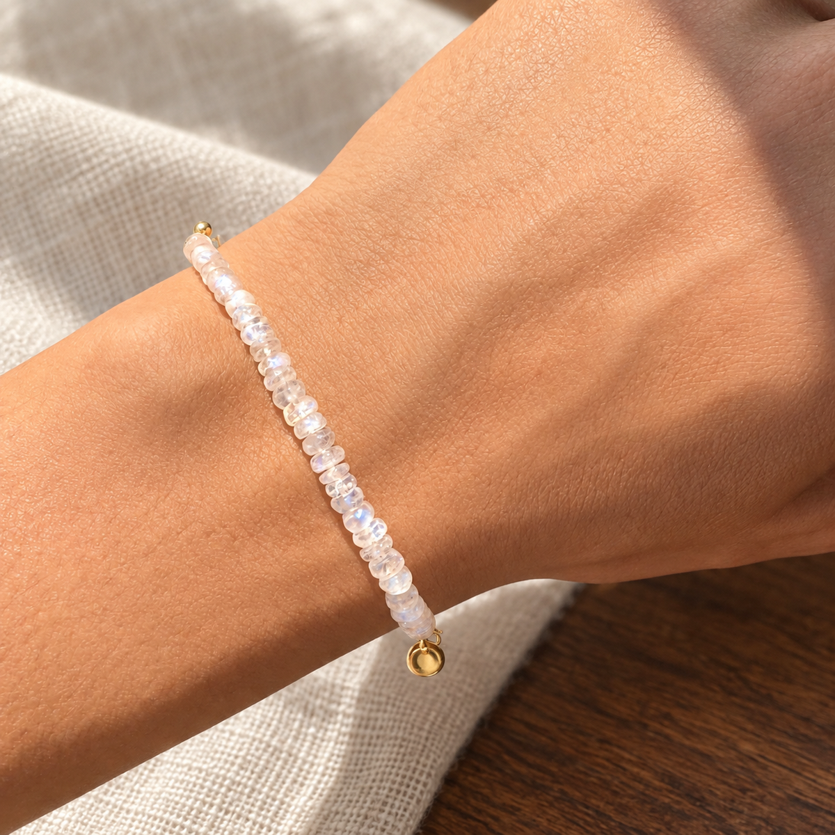 Lunar Tide rainbow moonstone bracelet, yellow gold vermeil wrist daylight view. One bracelet; photo props not included.