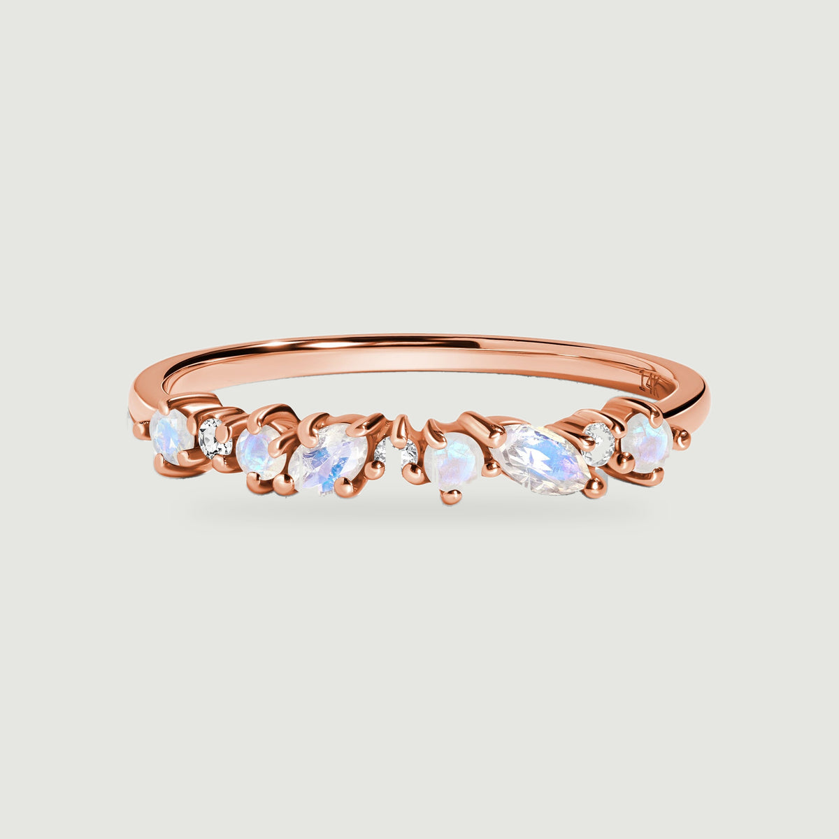 A rose gold ring displays round and oval moonstones alternating with small clear diamonds.