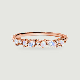 A rose gold ring displays round and oval moonstones alternating with small clear diamonds.