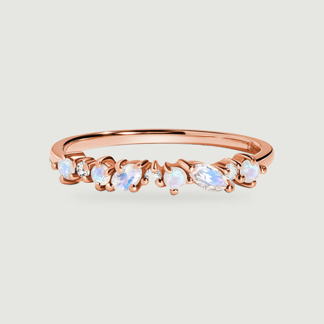 A rose gold ring displays round and oval moonstones alternating with small clear diamonds.