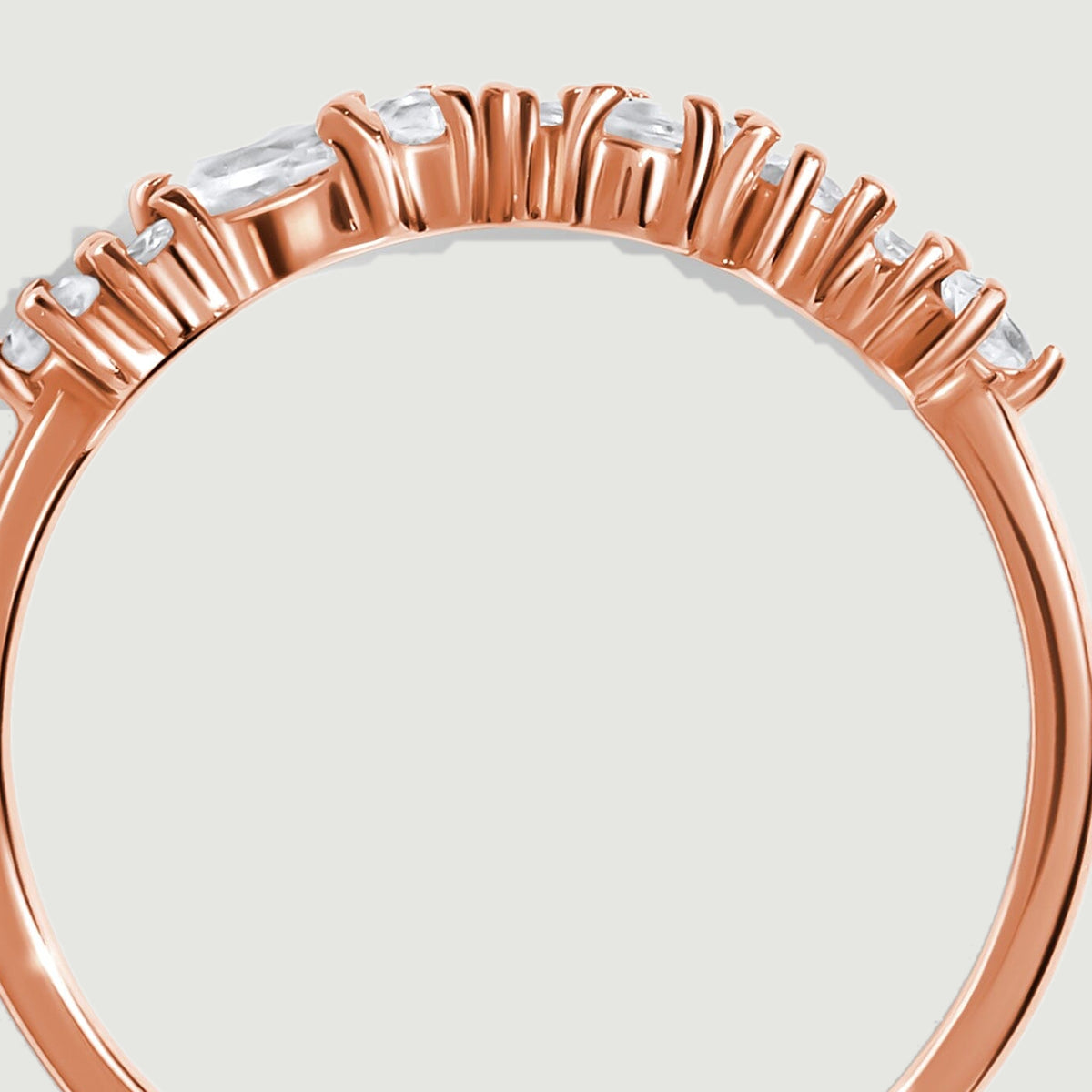 The raised rose gold baskets and individual prongs are visible beneath the gemstone row.