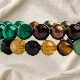 Close-up of malachite stripes, golden citrine and dark beads in the bracelet pair.