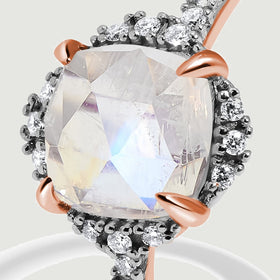 A close view shows rose gold prongs around the moonstone and individual diamonds along its halo.
