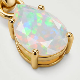 An angled close-up of the yellow gold setting shows four rounded prongs around the pear-shaped opal.