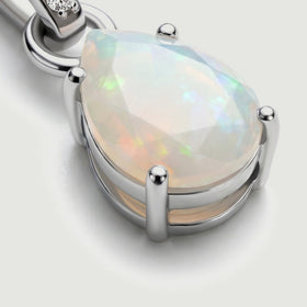 The angled silver setting reveals rounded prongs around the pale opal and the metal edge beneath the stone.