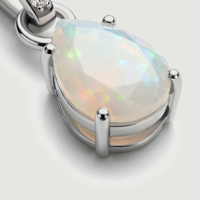 The angled silver setting reveals rounded prongs around the pale opal and the metal edge beneath the stone.
