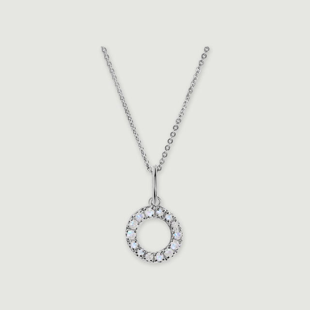 A silver chain holds a stone-set letter O pendant against a light gray background.