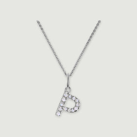 A silver chain holds a stone-set letter P pendant against a light gray background.