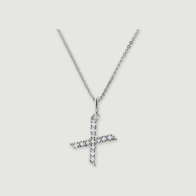 A silver chain holds a stone-set letter X pendant against a light gray background.