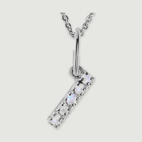 A close view reveals the pale stones and polished silver prongs on the letter I pendant.