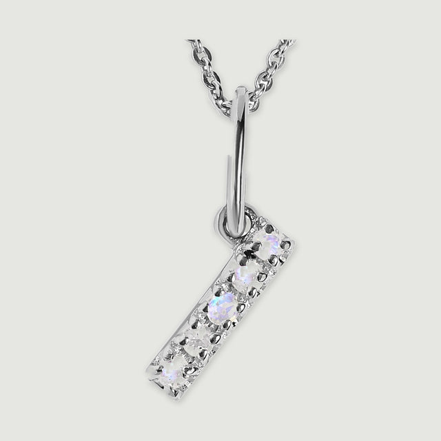 A close view reveals the pale stones and polished silver prongs on the letter I pendant.
