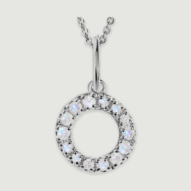A close view reveals the pale stones and polished silver prongs on the letter O pendant.