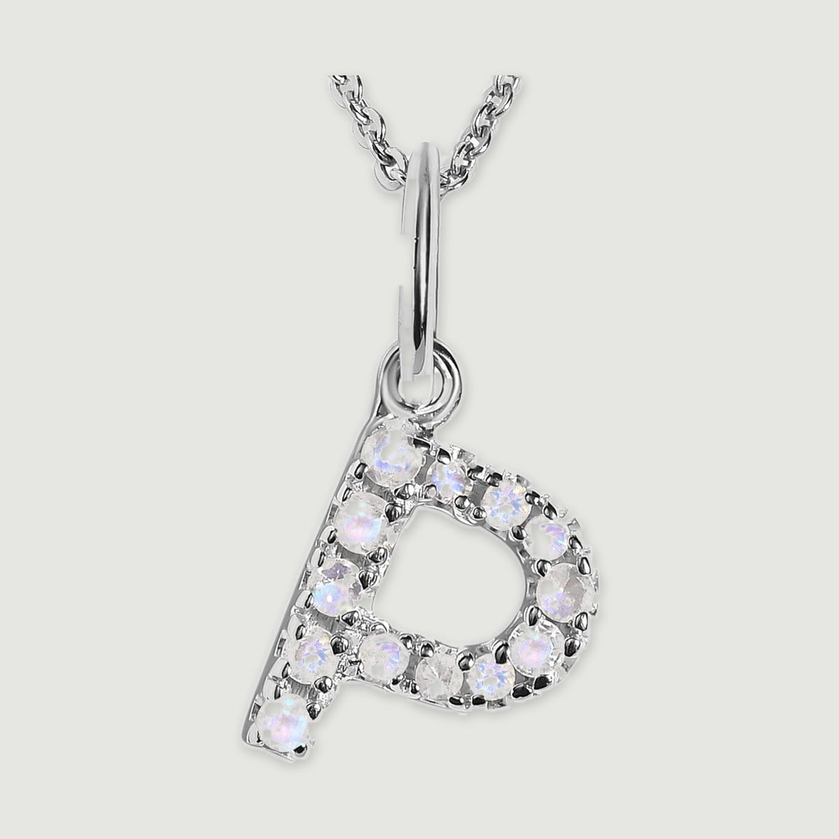 A close view reveals the pale stones and polished silver prongs on the letter P pendant.
