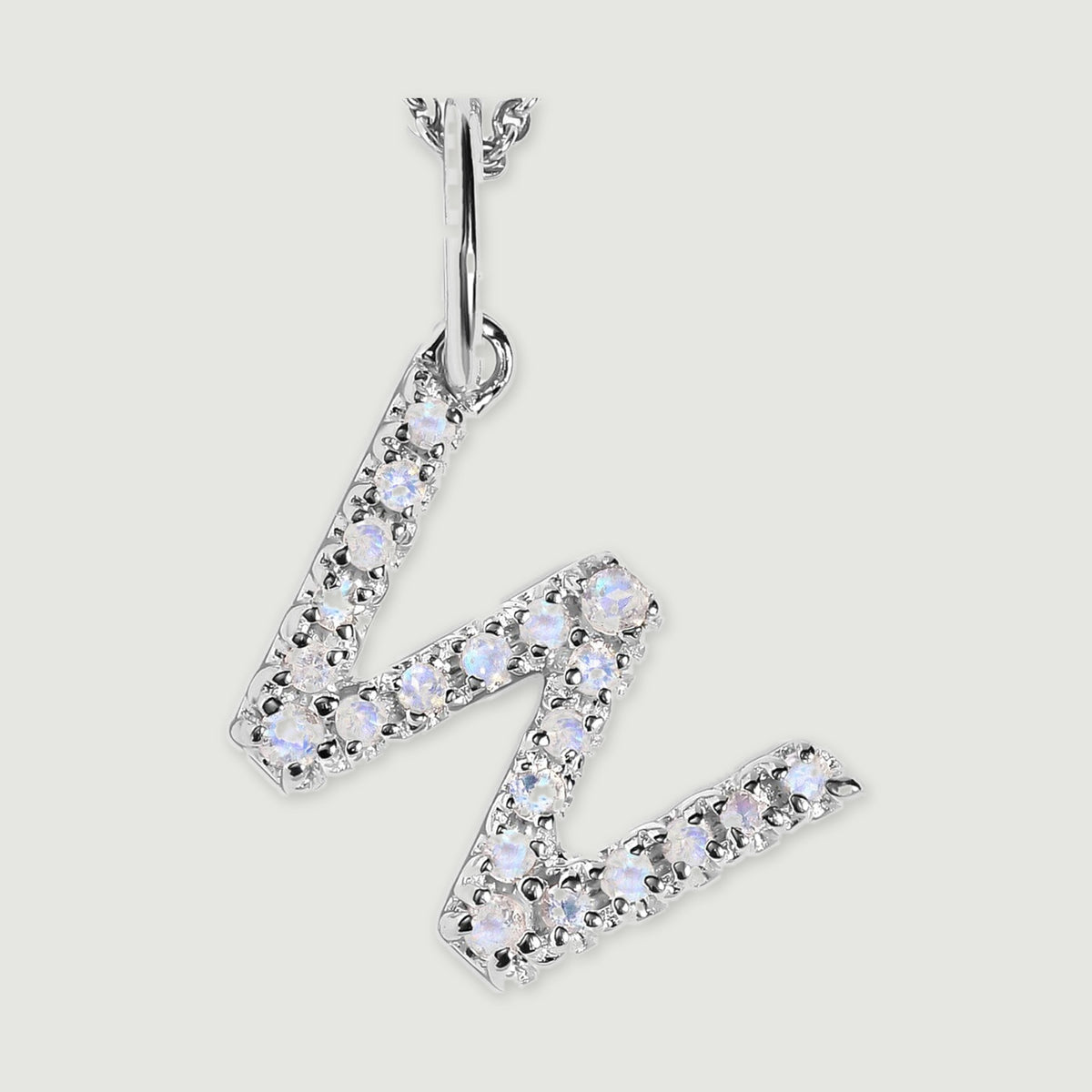 A close view reveals the pale stones and polished silver prongs on the letter W pendant.