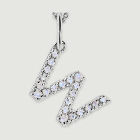 A close view reveals the pale stones and polished silver prongs on the letter W pendant.