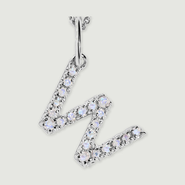A close view reveals the pale stones and polished silver prongs on the letter W pendant.