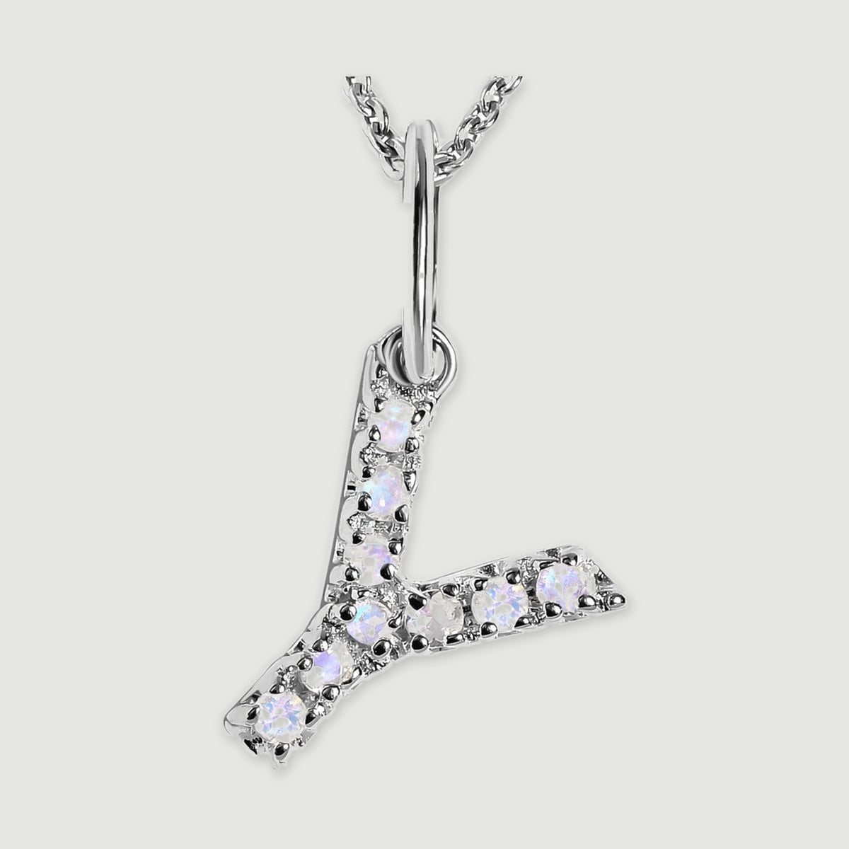 A close view reveals the pale stones and polished silver prongs on the letter Y pendant.
