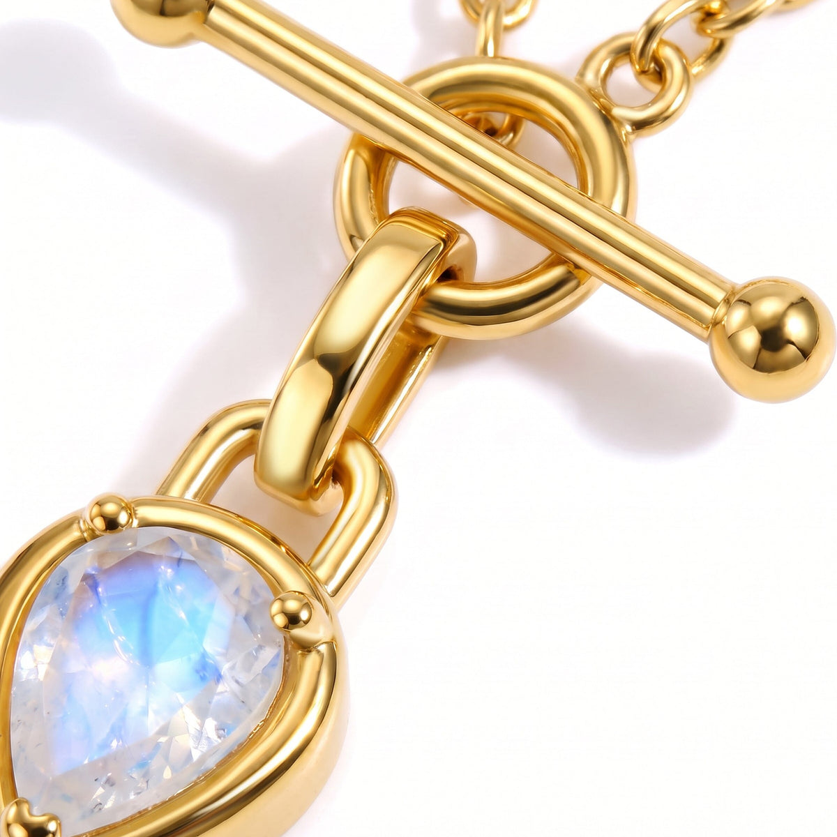 Macro detail of a toggle bar, linked chain, and luminous round blue-white stone in a setting.