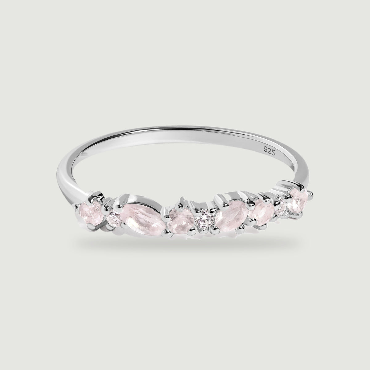 A polished silver band displays alternating pink stones and clear round accents against a light gray background.