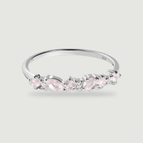 A polished silver band displays alternating pink stones and clear round accents against a light gray background.