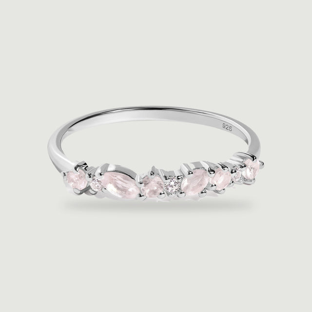 A polished silver band displays alternating pink stones and clear round accents against a light gray background.
