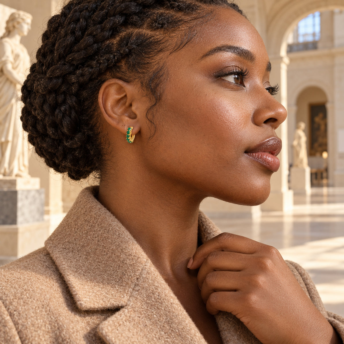 A woman with a braided updo wears a yellow gold plated green onyx hoop inside a stone gallery.