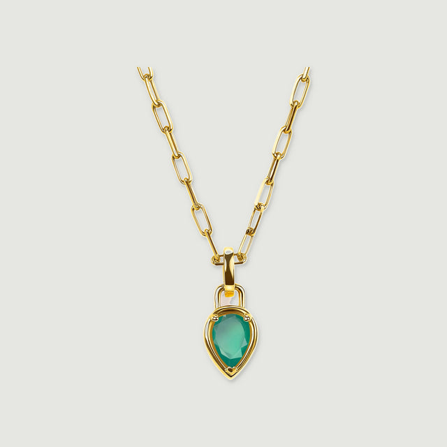 A yellow gold plated necklace with elongated links and a pear-shaped green pendant is centered on a pale gray background.