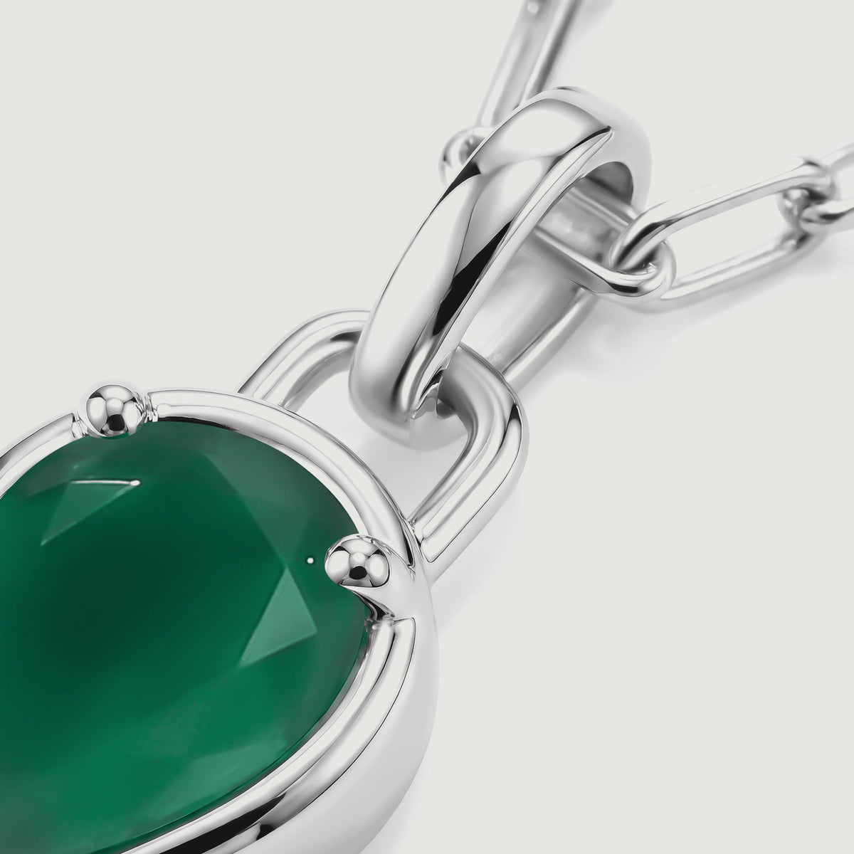 The white rhodium plated bail, connecting loop and green stone are shown in a diagonal close-up.