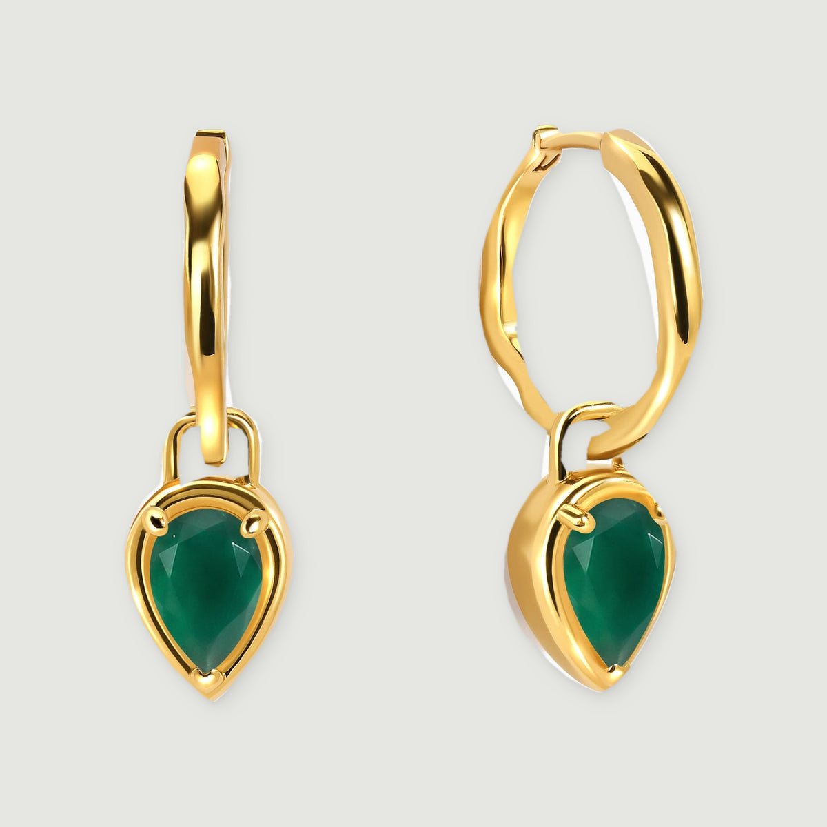 A pair of yellow gold plated hoops with pear-shaped green stones is centered on a light gray background.