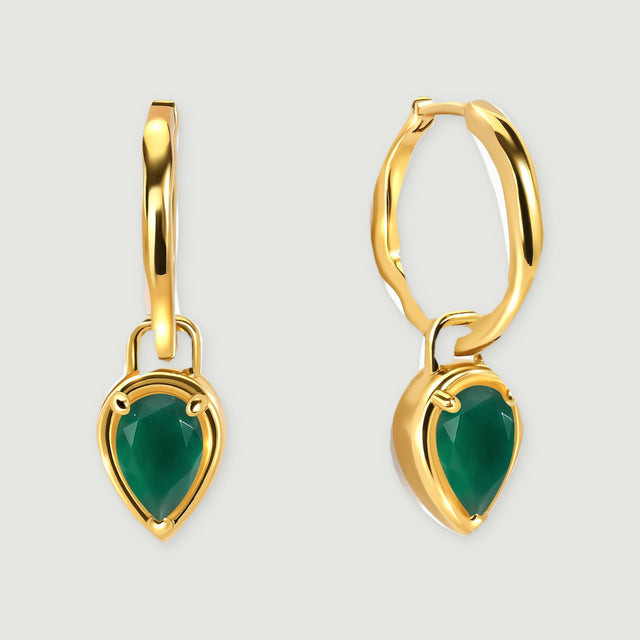 A pair of yellow gold plated hoops with pear-shaped green stones is centered on a light gray background.